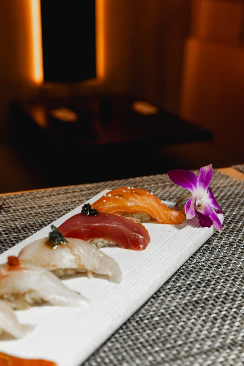 Chef nigiri flight with purple orchid flower garnish