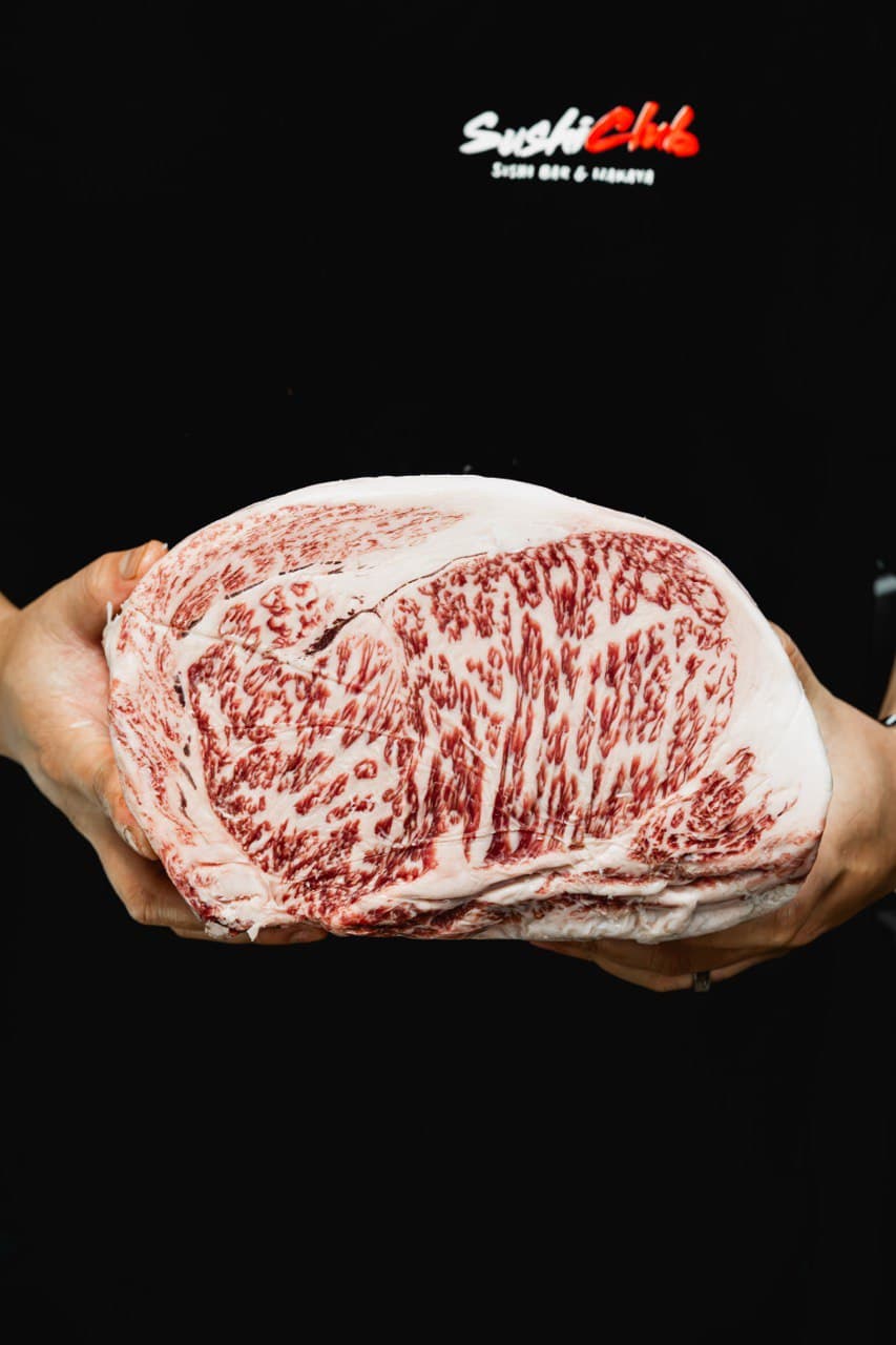 Chef displaying massive marbled A5 Wagyu ribeye block