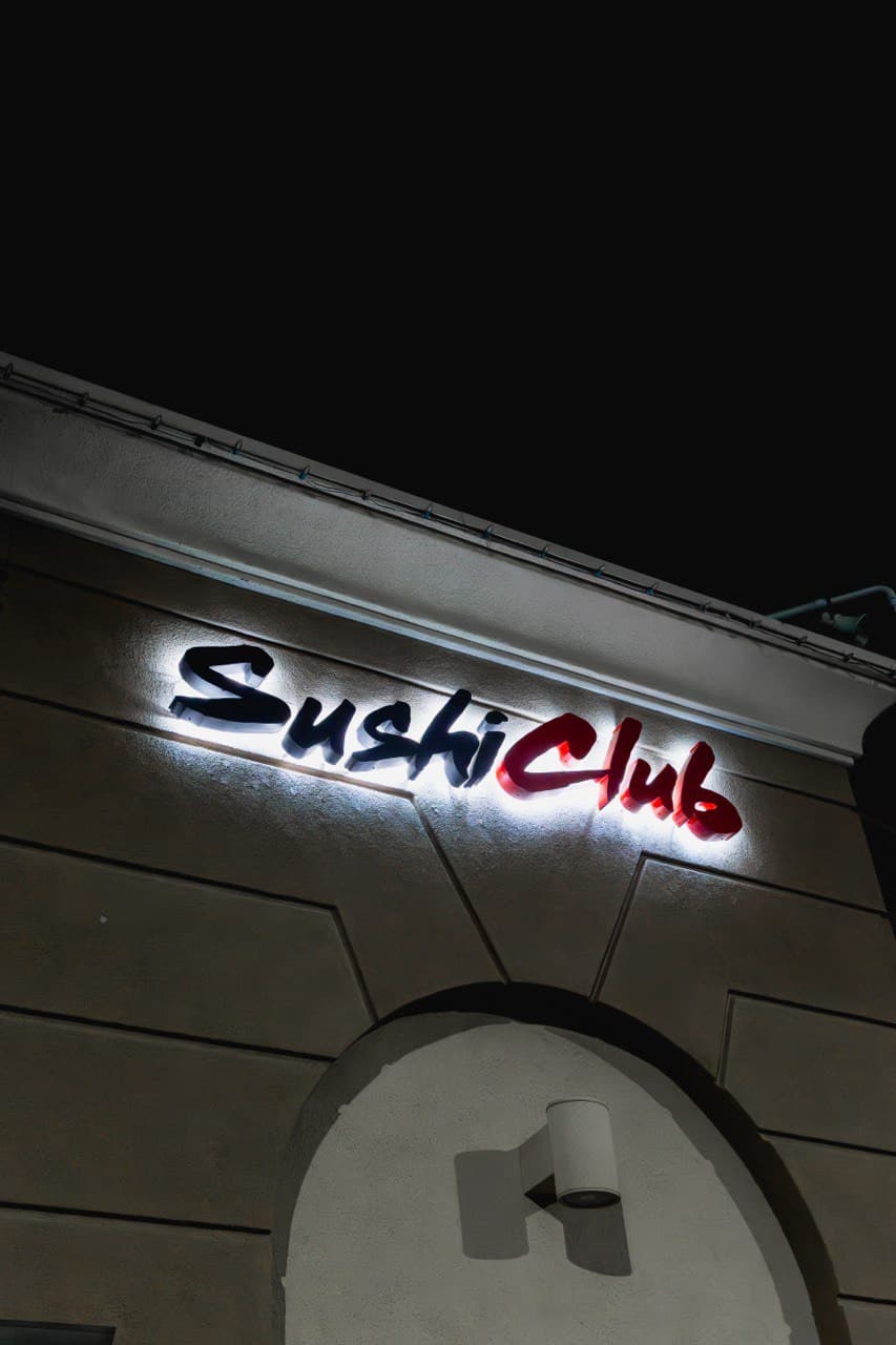 Sushi Club Izakaya illuminated nighttime exterior on Associated Road in Brea